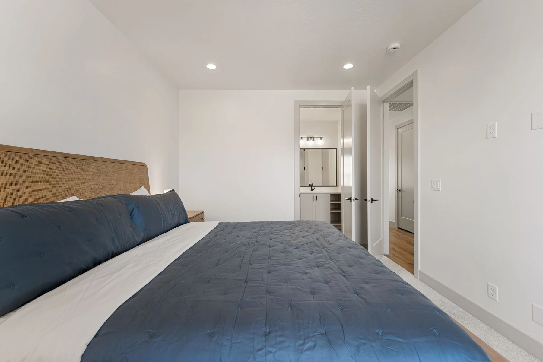 King bedroom with blue bedding and natural light – Isle 64 vacation rental in Washington, Utah near St. George and Zion