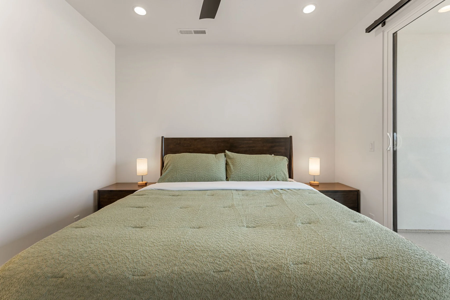 Green-accented king bedroom with television – Isle 64 vacation rental in Washington, Utah near St. George and Zion