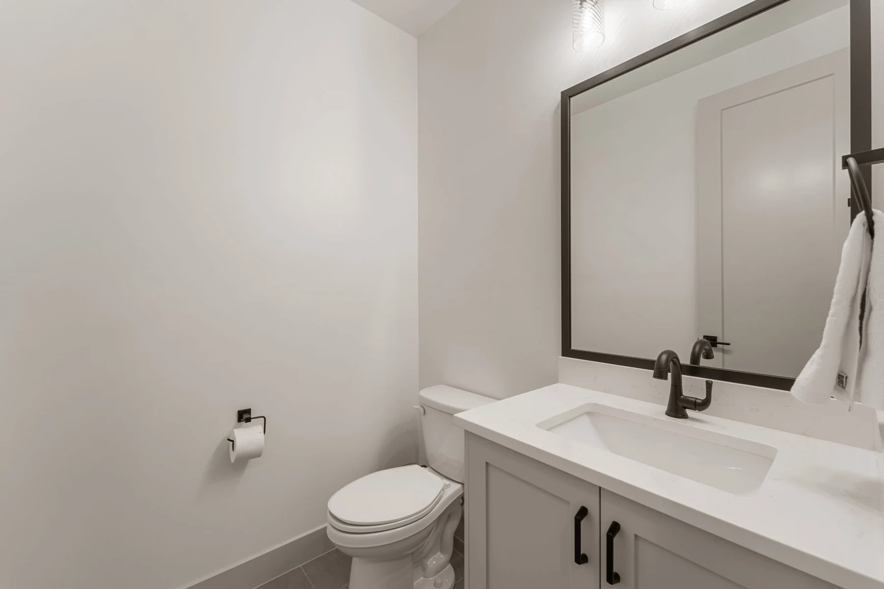 Guest bathroom with round mirror – Isle 64 vacation rental in Washington, Utah near St. George and Zion