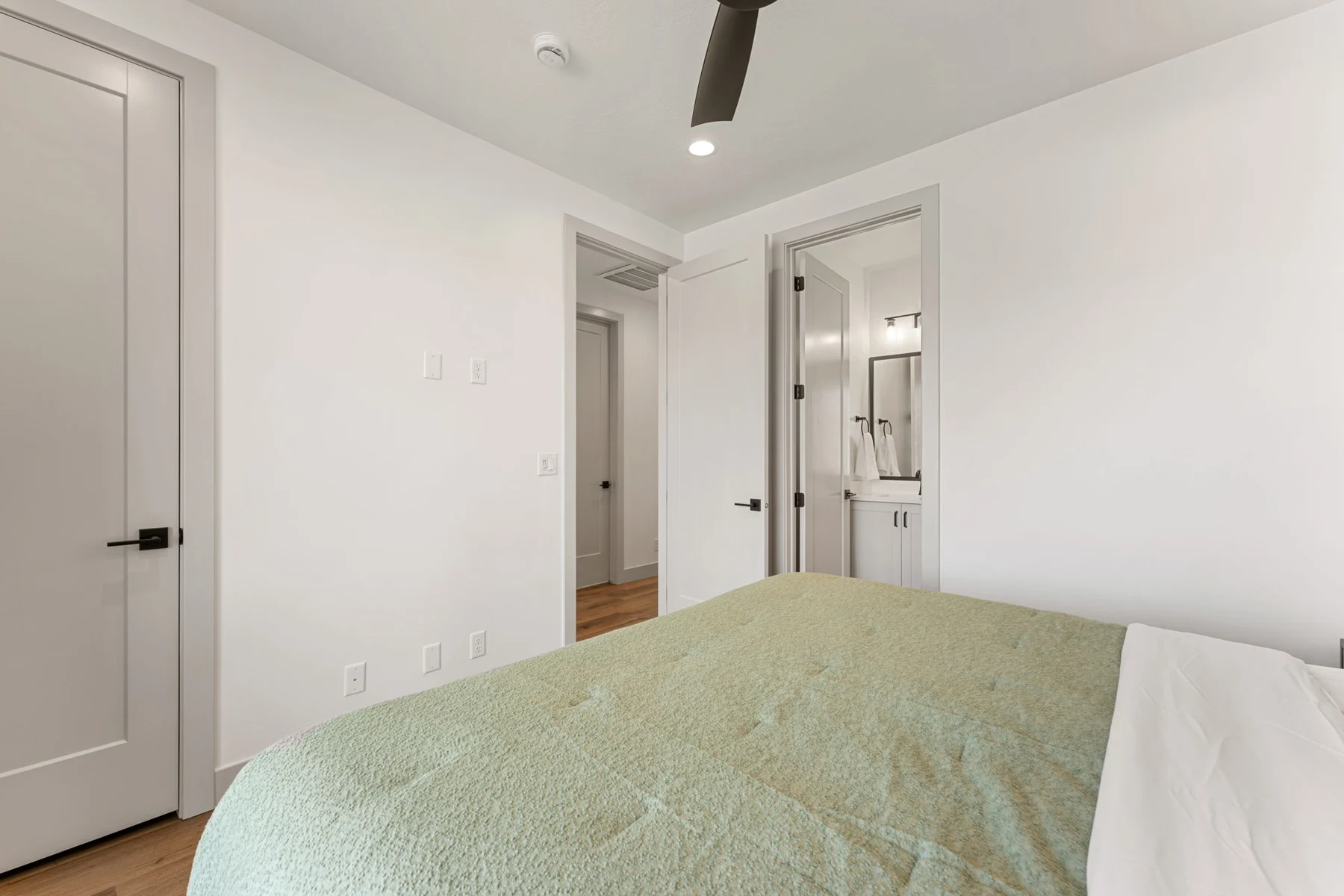 King bedroom with green bedding – Isle 64 vacation rental in Washington, Utah near St. George and Zion